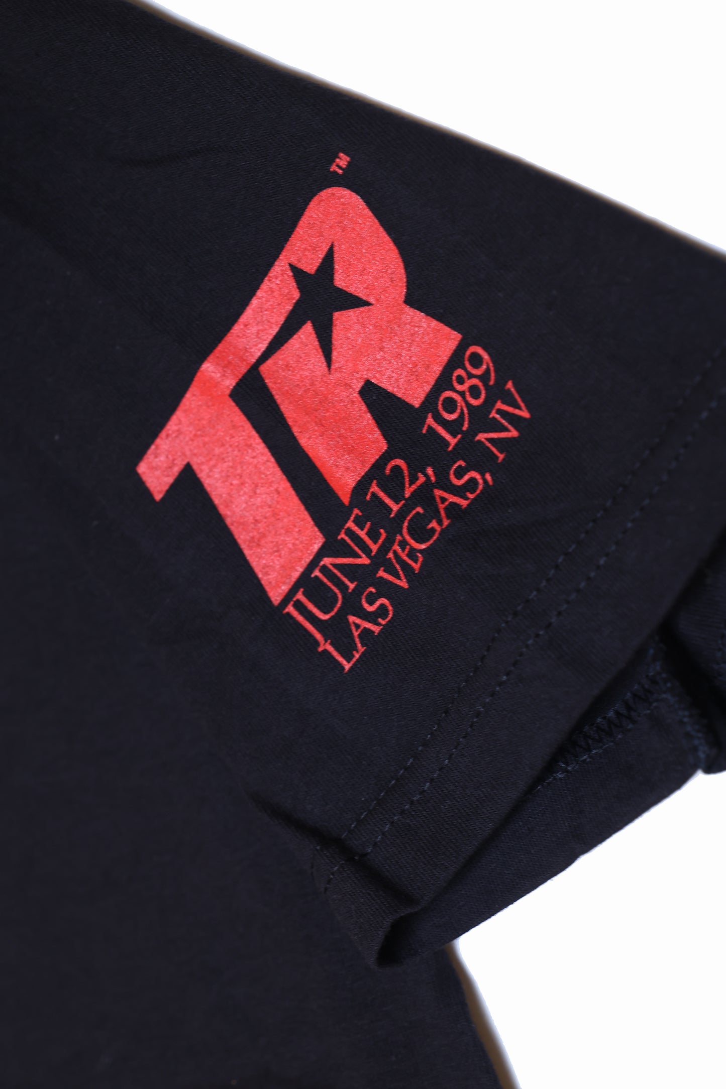 Black shirt with red logo and text on a white background