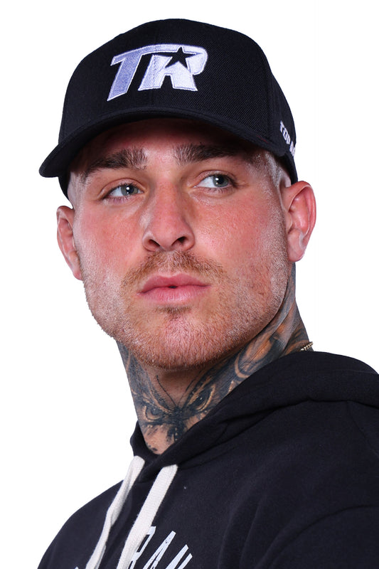 Man wearing a black snapback hat with a white embroidered Top Rank logo, paired with a black hoodie.